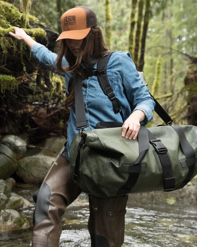 A woman carrying the Filson dry duffle bag.