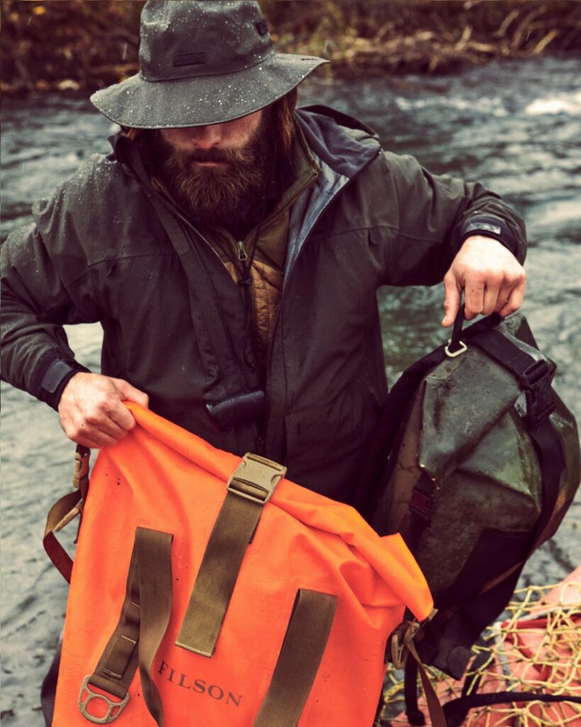 A man carrying multiple waterproof Filson dry bags.